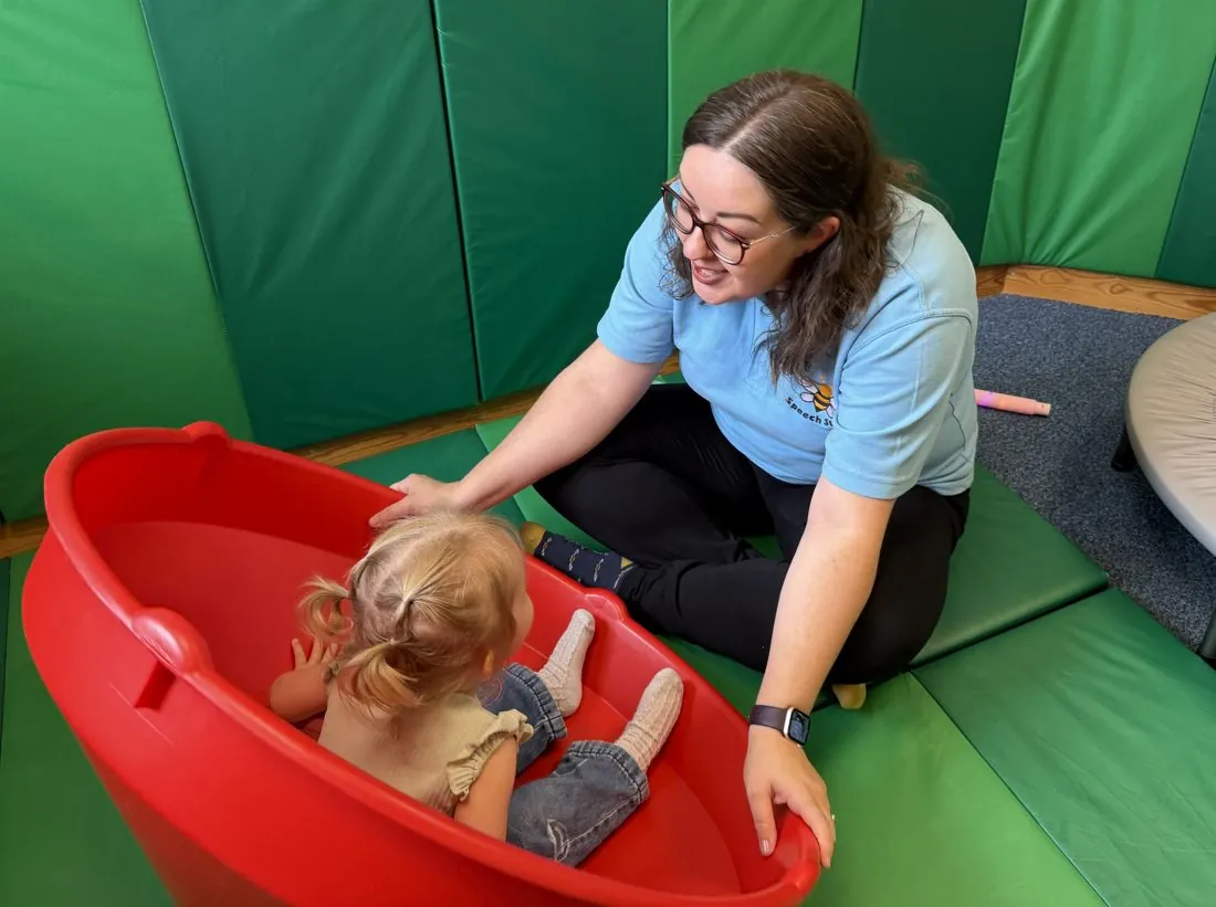 Therapist supporting a child in sensory play